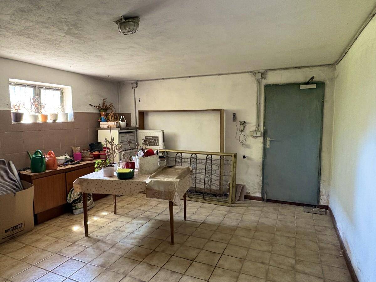 Kellerraum mit Fliesenboden, Fenster und Stauraum für verschiedene Gegenstände.