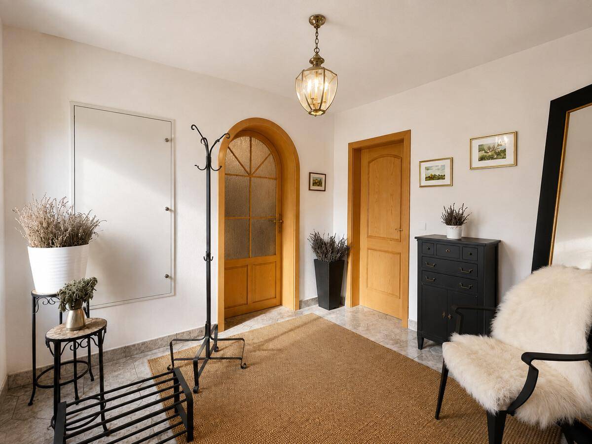 Heller Eingangsbereich mit Fliesenboden, Garderobe und dekorativen Elementen.