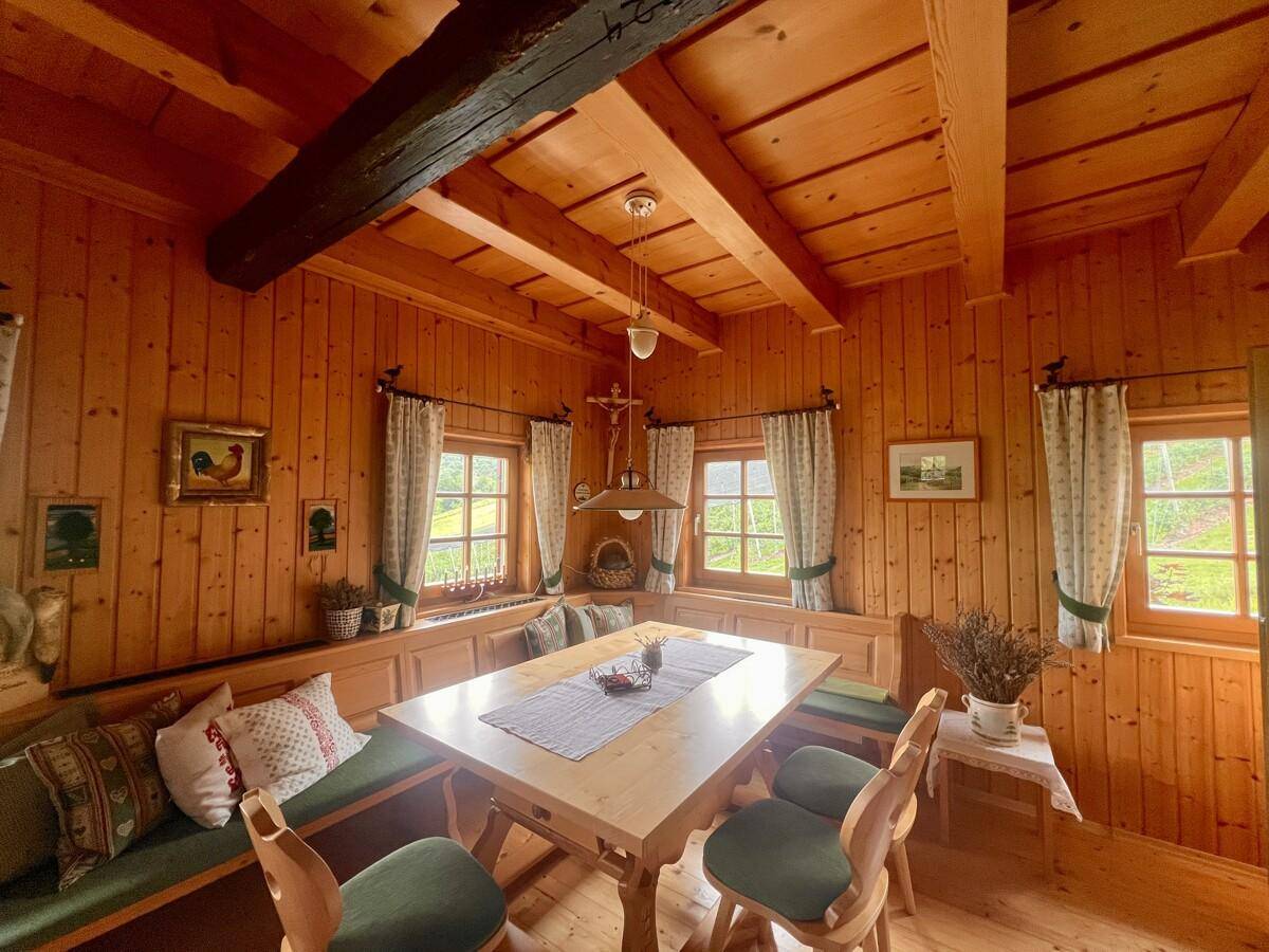 Gemütlicher Essbereich im alpinen Stil mit Holztäfelung, Holzbalken und traditioneller Eckbank.