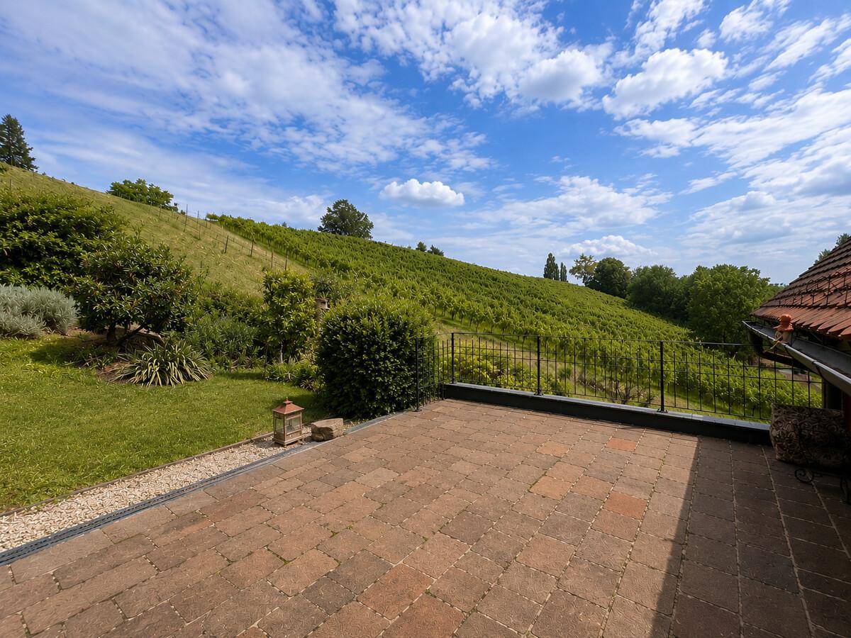 Große gepflasterte Terrasse mit weitem Blick auf die Weinberge und Hügellandschaft.