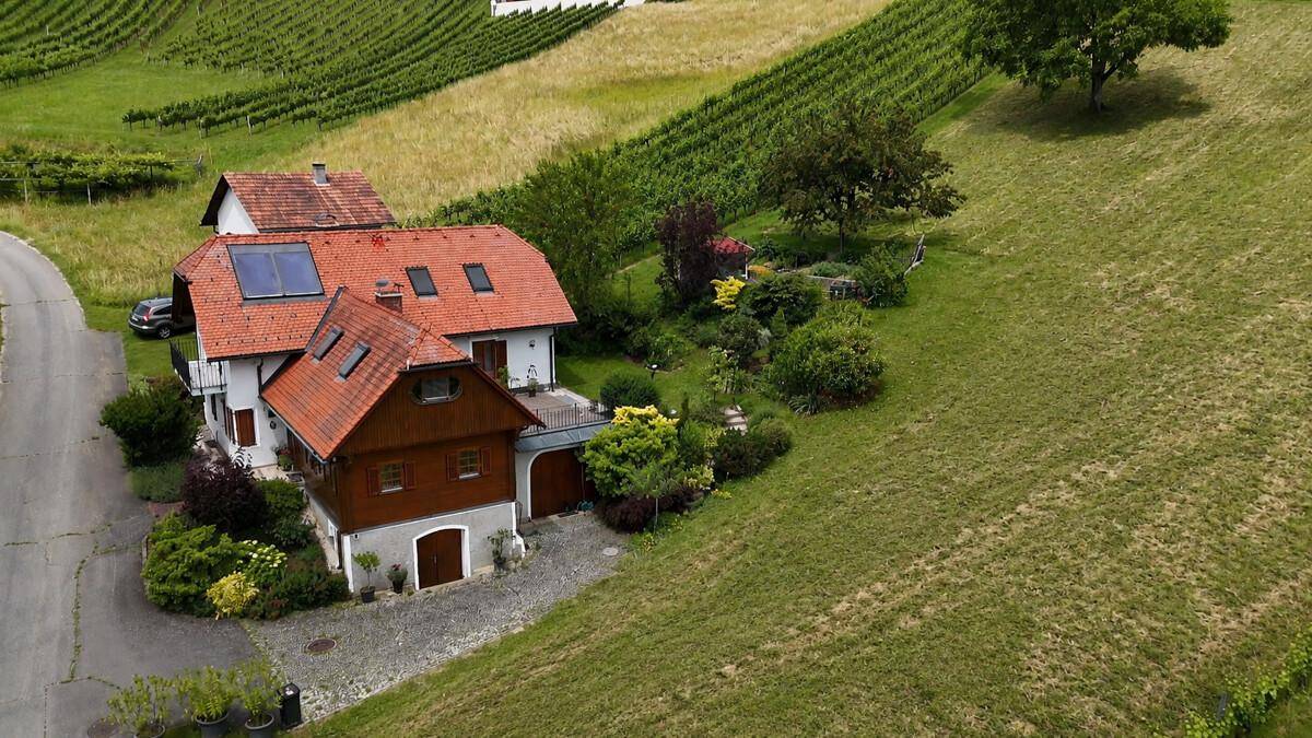 Luftaufnahme eines Anwesens mit mehreren Gebäuden, umgeben von Weinbergen und Natur.