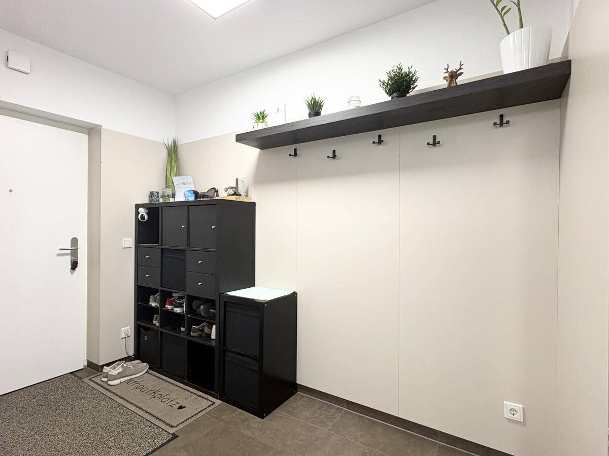 Heller Eingangsbereich mit Schuhregal, Garderobe und Ablagefläche.