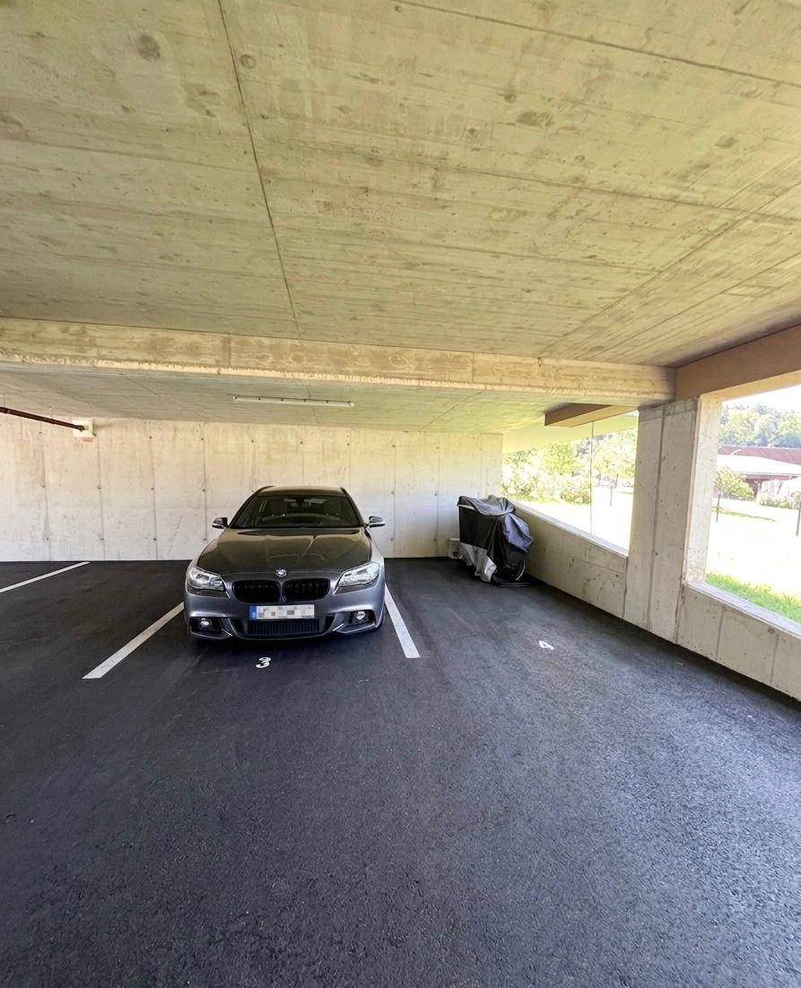 Tiefgarage mit einem Stellplatz und Sichtbetonwänden.