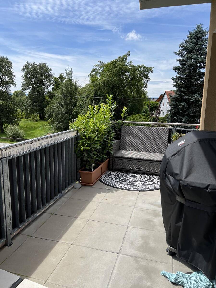 Geräumiger Balkon mit Grillbereich, Sitzgelegenheiten und Blick ins Grüne.