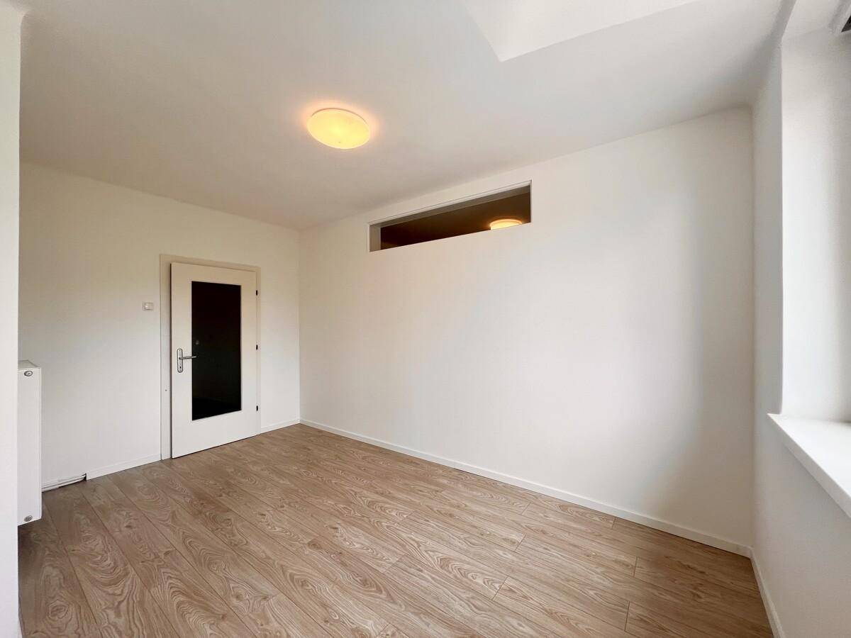 Heller Raum mit Laminatboden und Tür, der als Flur oder kleines Arbeitszimmer genutzt werden könnte.