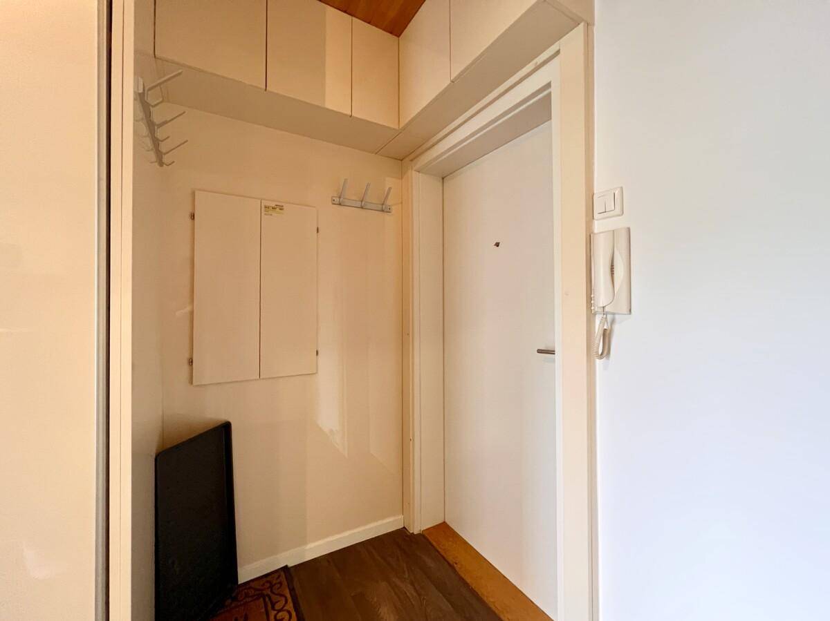 Eingangsbereich mit Garderobe, Gegensprechanlage und Holzpaneeldecke, bietet praktischen Stauraum.