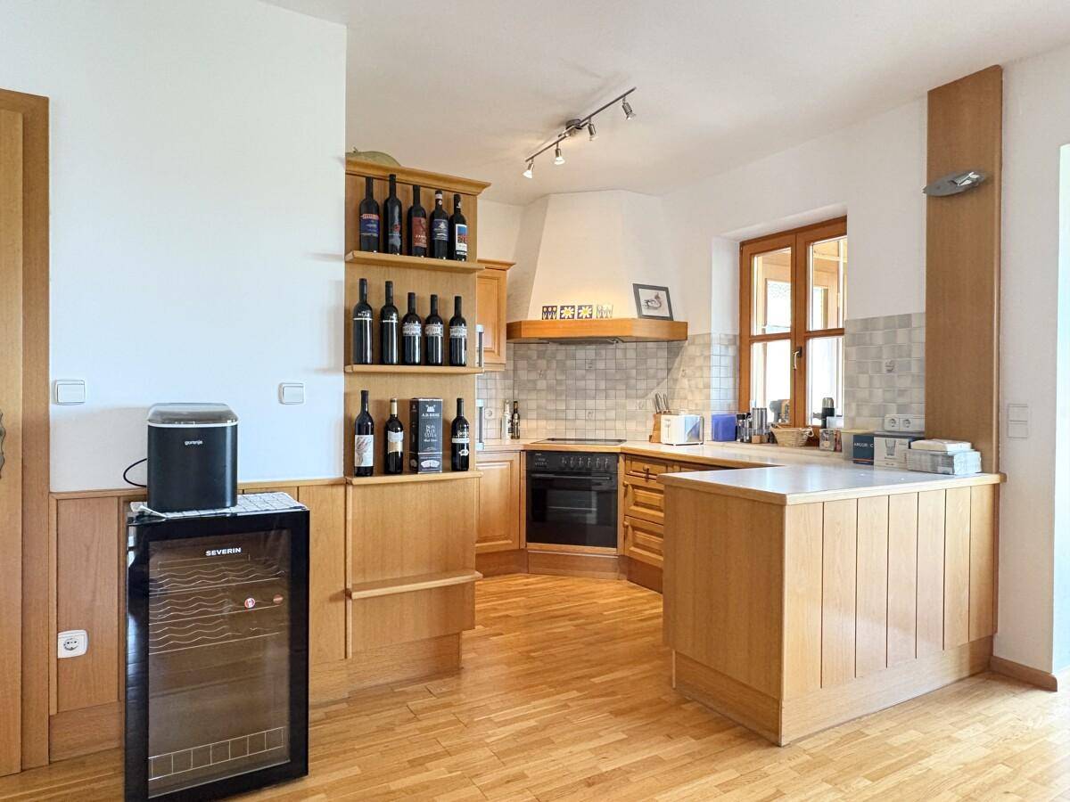 Funktionale Holzküche mit integrierten Weinregalen und praktischer Arbeitsfläche.