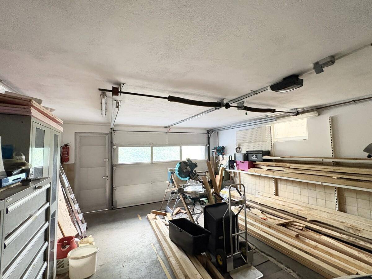 Geräumige Garage mit Lagerflächen und Werkzeugen, ideal für Hobby und Abstellzwecke.