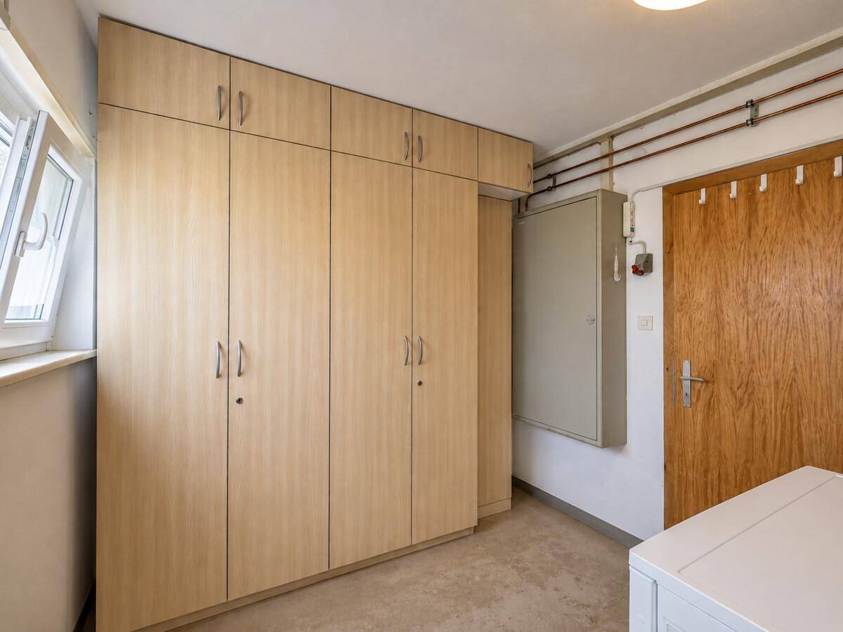 Praktischer Abstellraum mit Einbauschränken und Fenster für zusätzlichen Stauraum.