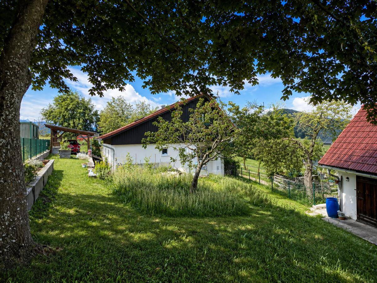 Idyllischer Gartenbereich mit altem Baumbestand und Blick auf das Landhaus.