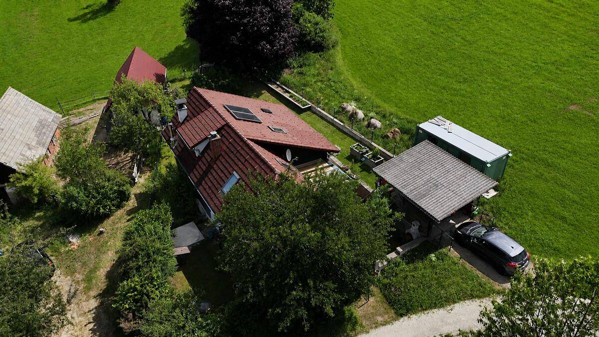 Luftaufnahme des Hauses mit Carport, Garten und weitem Blick über die grüne Landschaft.