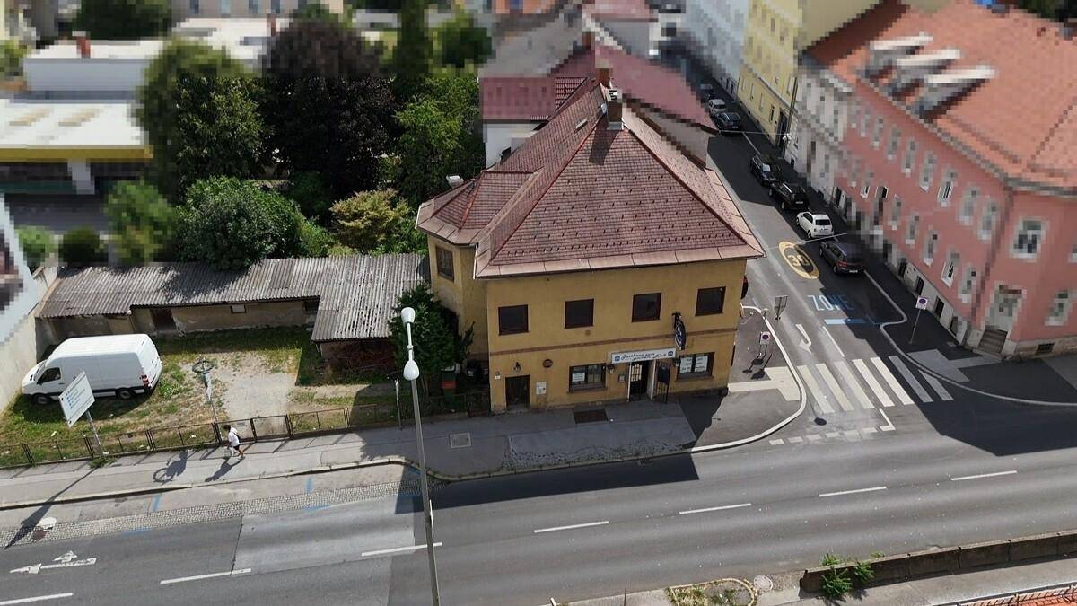 Überblick aus der Vogelperspektive auf das Gebäude mit rotem Ziegeldach und angrenzender Straße.