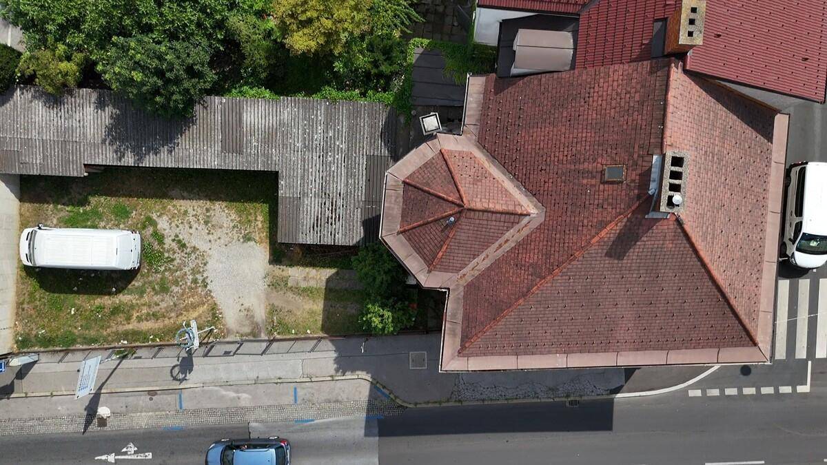 Direkte Draufsicht auf das Gebäude mit seinem markanten Dach und dem angrenzenden Grundstück.