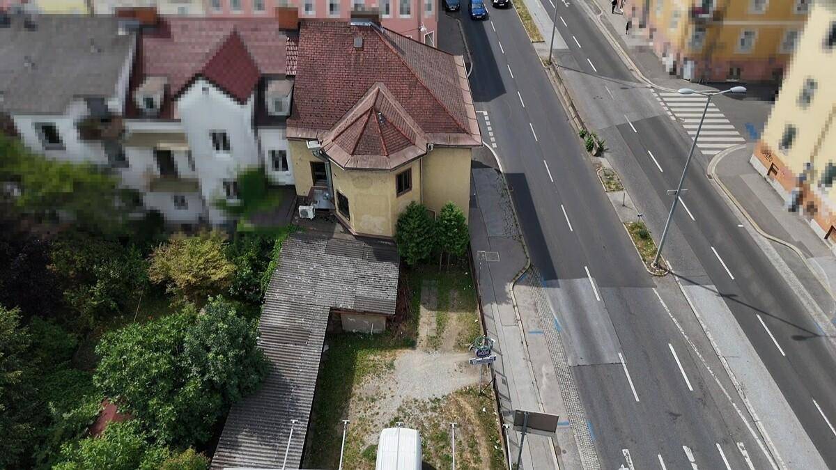 Überblick aus der Vogelperspektive auf das Gebäude mit rotem Ziegeldach und angrenzender Straße.