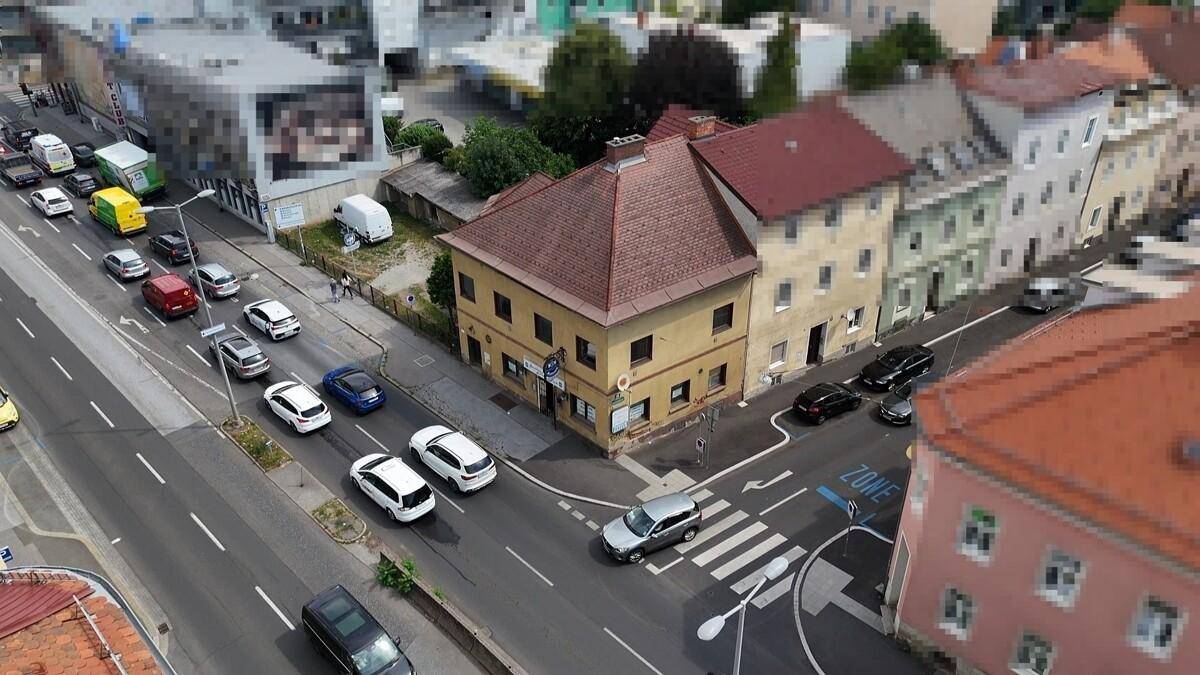 Luftaufnahme einer belebten Straße mit vielen Fahrzeugen und dem Gebäude im städtischen Kontext.