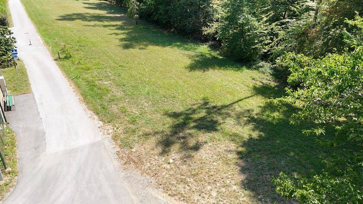 Übersicht aus der Vogelperspektive auf ein grünes Grundstück mit Zufahrtsweg.