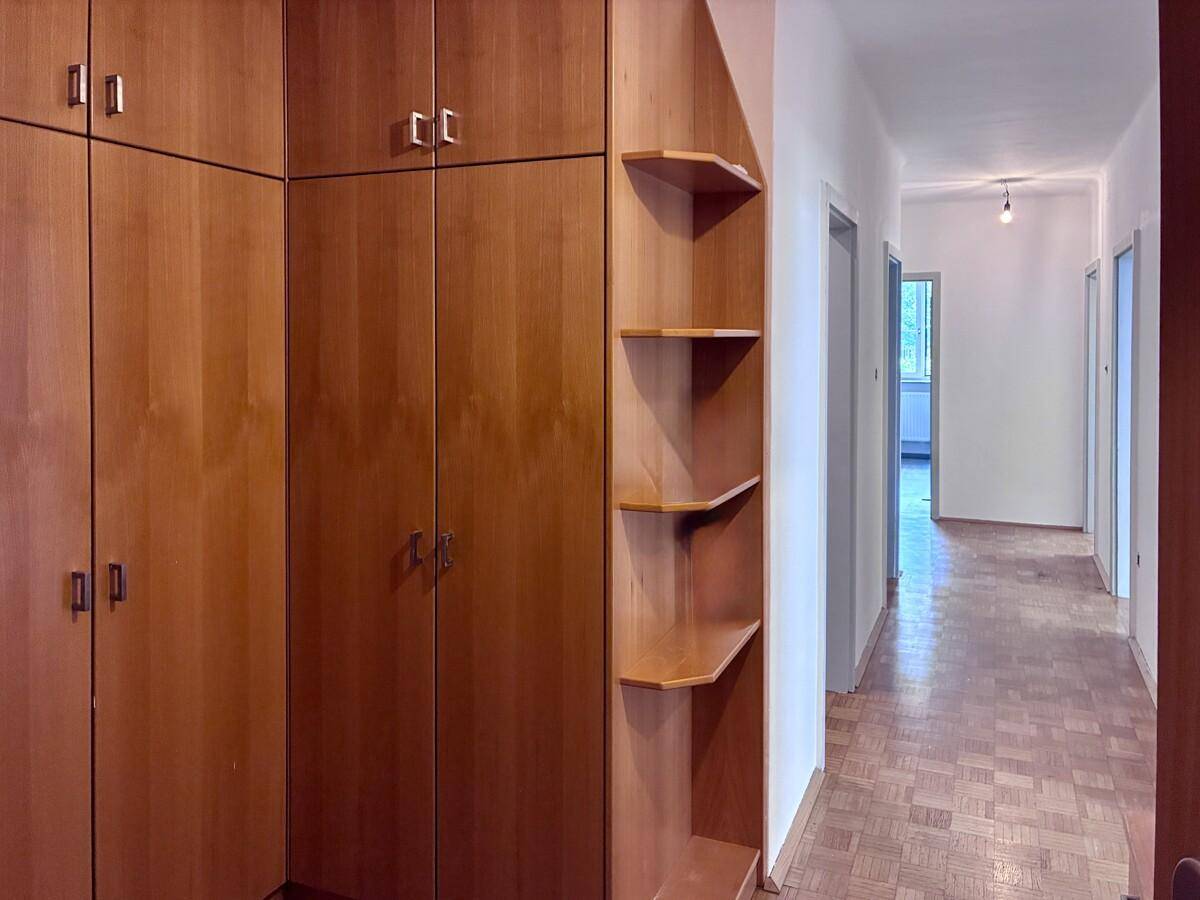 Langer Flur mit praktischen Einbauschränken und Regalen aus Holz für zusätzlichen Stauraum.
