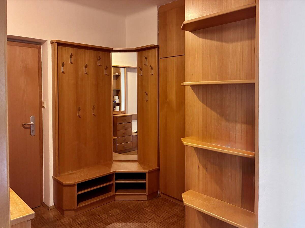 Gemütlicher Eingangsbereich mit maßgefertigten Holzmöbeln, Garderobe und Spiegel.