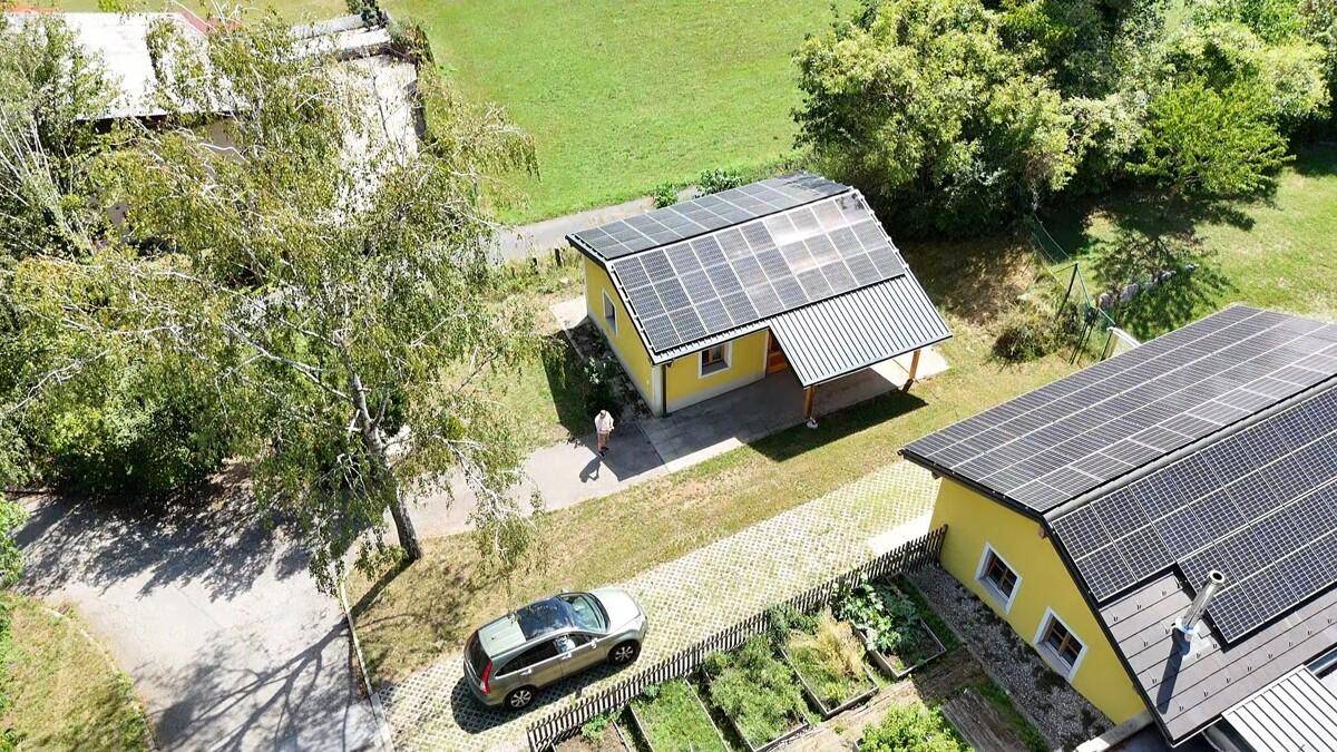 Luftaufnahme von zwei Häusern mit Solaranlagen und einem kleinen Gemüsegarten.