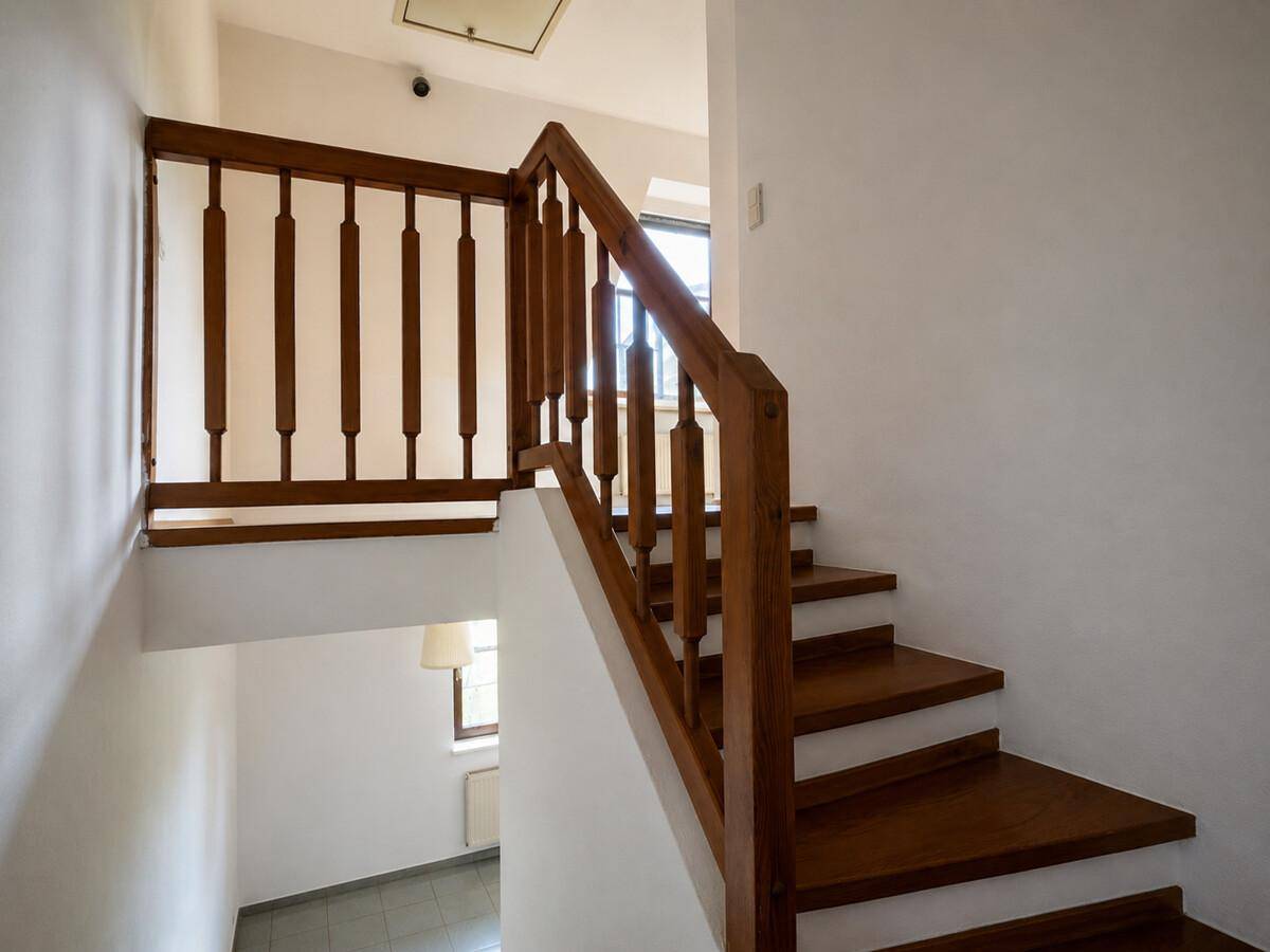 Holztreppe mit Geländer führt in die obere Etage, hell und gut erhalten.