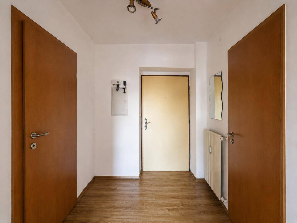 Heller Eingangsbereich mit Laminatboden und Holztüren, einladend und funktional.