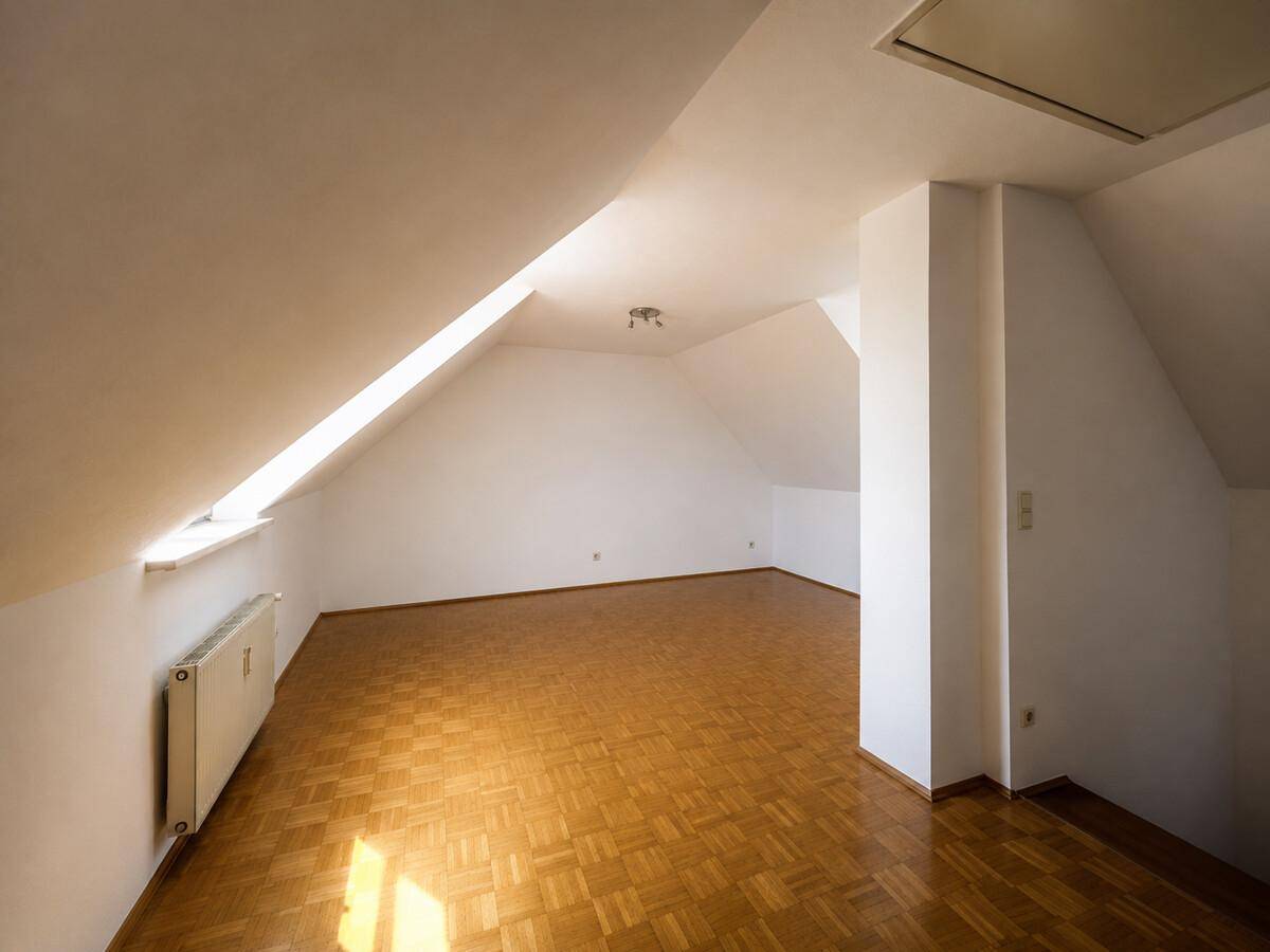 Helles Dachzimmer mit Parkettboden und Dachfenster, bietet vielseitige Nutzungsmöglichkeiten.