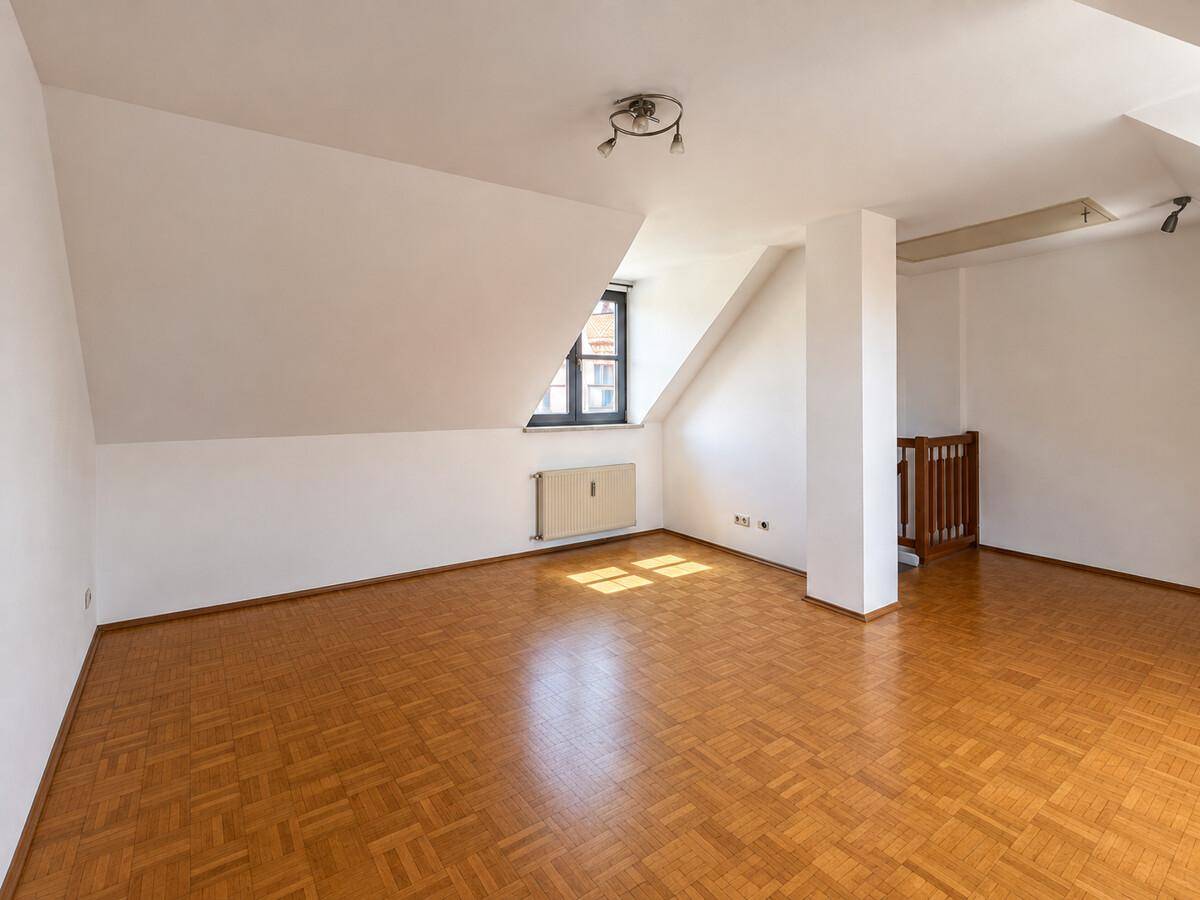 Großes Dachzimmer mit Parkettboden und schrägen Wänden, bietet vielseitige Nutzung.