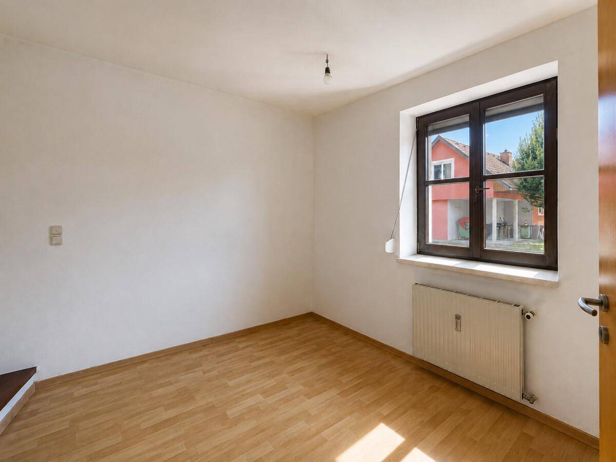 Geräumiges Zimmer mit Laminatboden und Fenster, bietet viel Tageslicht.