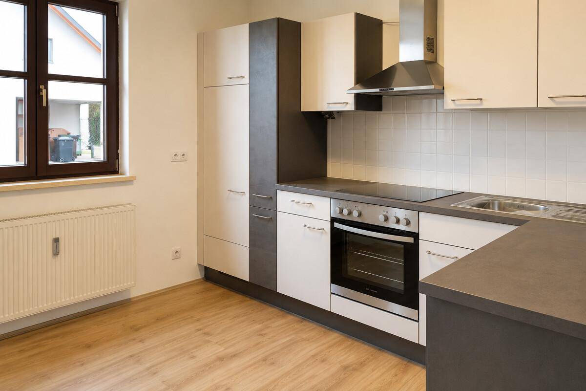 Detailansicht der modernen Küche mit Fenster, Heizkörper und hochwertigen Einbaugeräten.