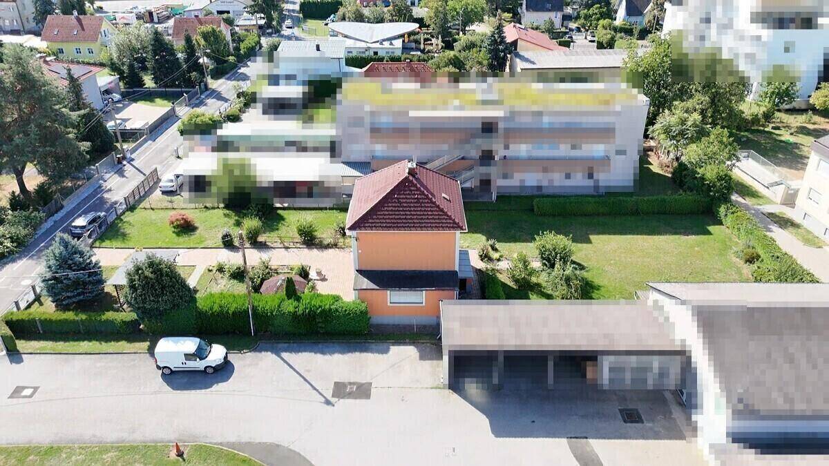 Luftaufnahme des Hauses von der Straße aus, mit Carport und umliegender Wohnbebauung.