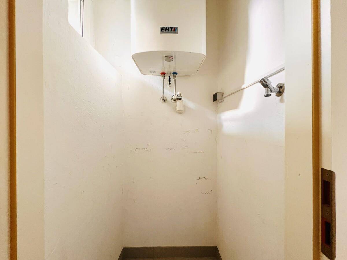 Kleiner Abstellraum mit Warmwasserboiler und einfacher Ausstattung.