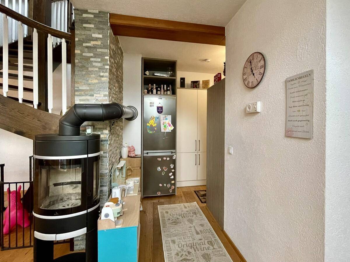 Eingangsbereich mit Kaminofen, integriertem Kühlschrank und Zugang zur Treppe.