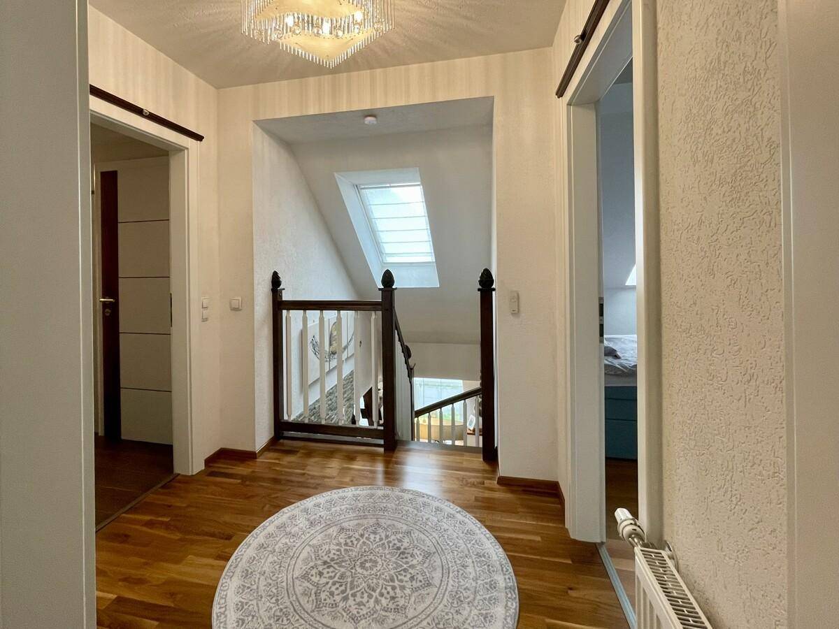 Geräumiger Flur mit Blick auf die Treppe und ein Dachfenster, das für Helligkeit sorgt.