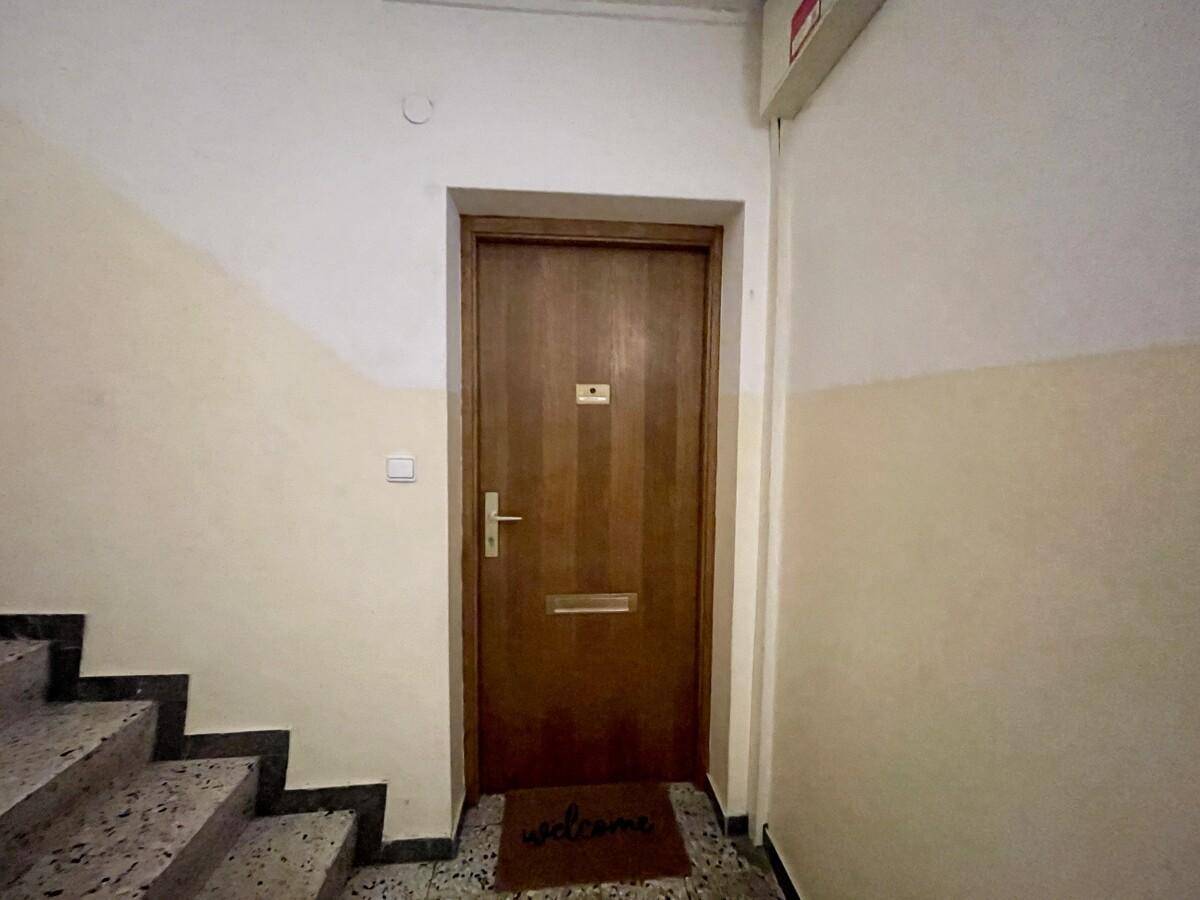 Eingangstür einer Wohnung im Treppenhaus mit Willkommensmatte.