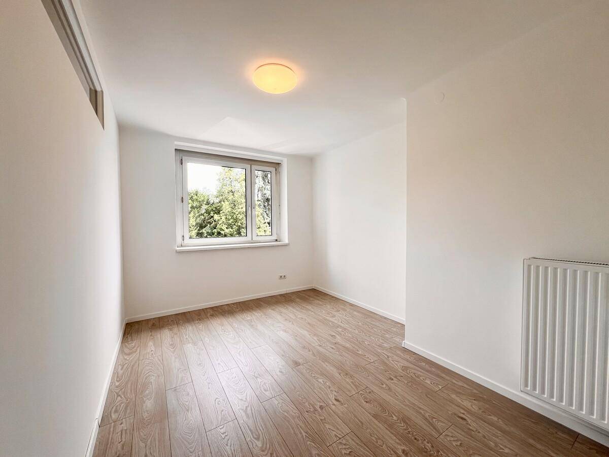 Helles Zimmer mit Laminatboden und großem Fenster, ideal als Schlaf- oder Arbeitszimmer.