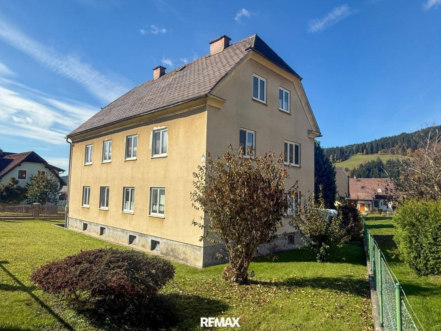Freistehendes Haus mit gelber Fassade und großem Garten in ländlicher Umgebung.
