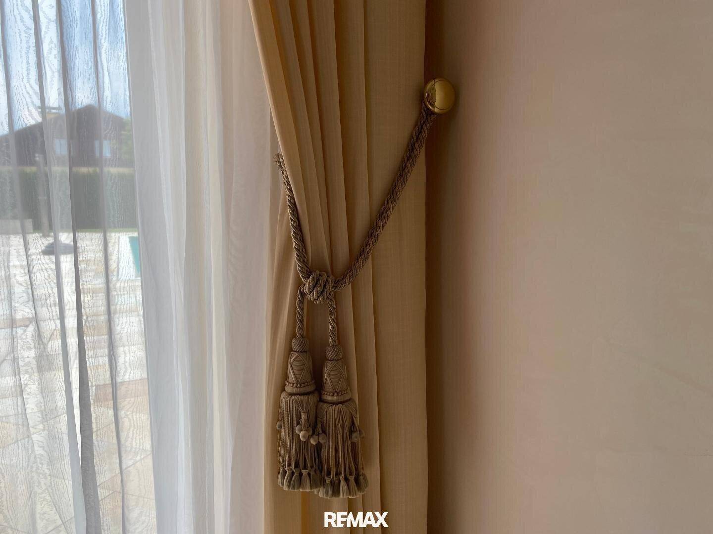 Detailaufnahme eines opulenten Vorhanghalters mit Quasten, der den klassischen Stil unterstreicht.