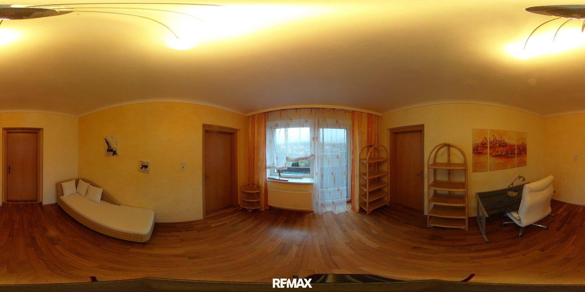 Schlafzimmer mit Holzboden, Fenster und einfacher Möblierung.