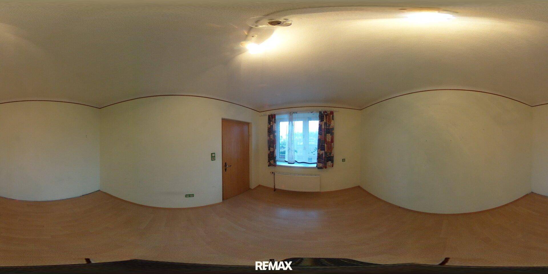 Leerer Raum mit Holzboden und Fenster, bereit zur individuellen Gestaltung.