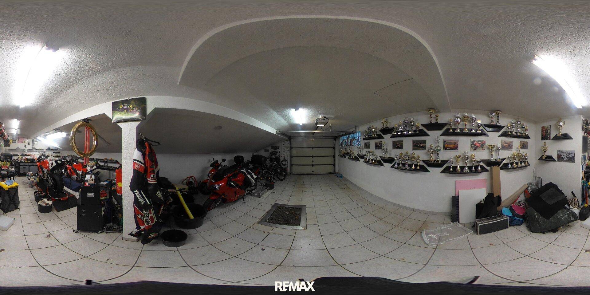 Geräumige Garage mit Fliesenboden, Platz für Fahrzeuge und Lagerung.