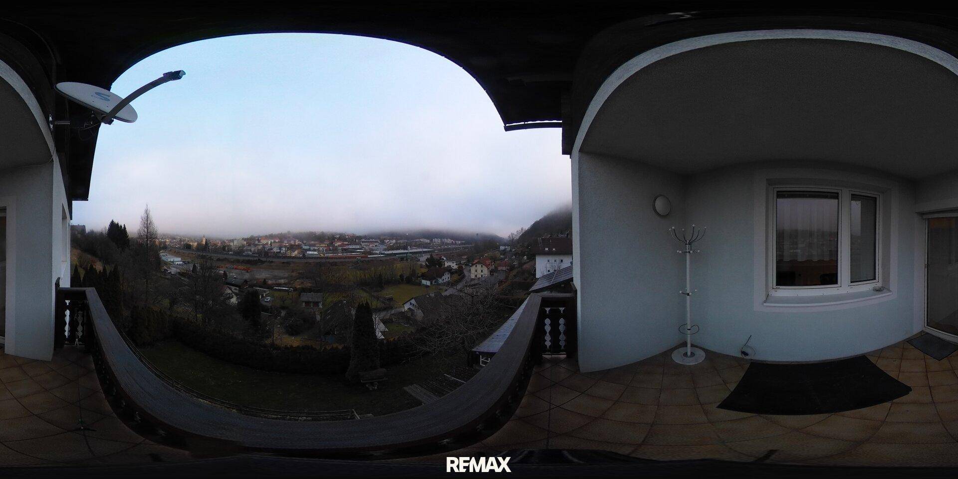 Balkon mit Panoramablick auf die grüne Umgebung und die Stadt in der Ferne.