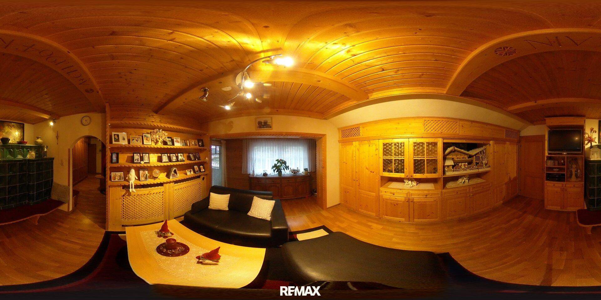 Gemütliches Wohnzimmer im alpinen Stil mit viel Holz, bequemen Sofas und traditionellen Dekorationen.