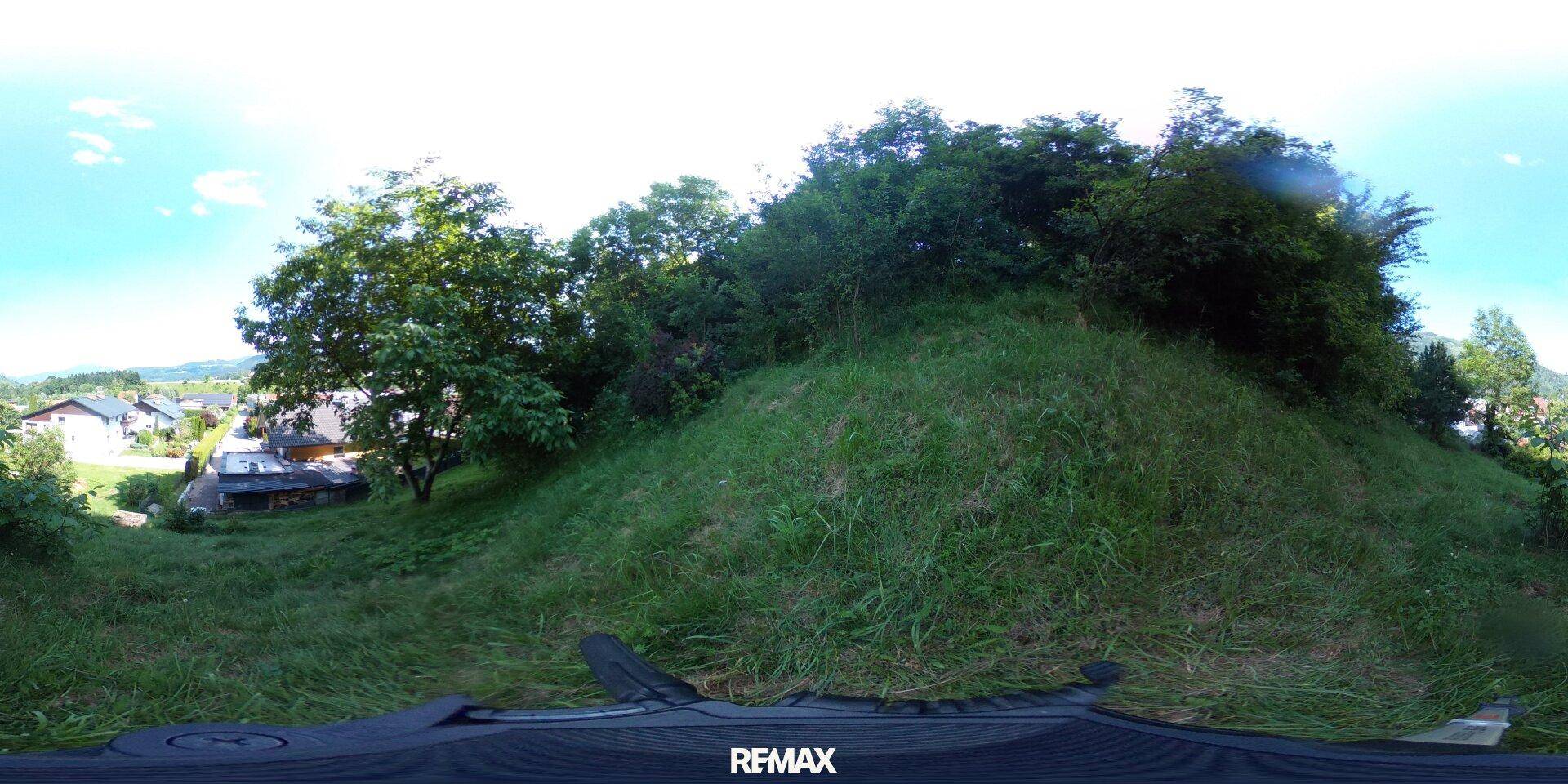 360-Grad-Panoramaansicht eines grünen Hanggrundstücks mit Blick auf die umliegende Bebauung.
