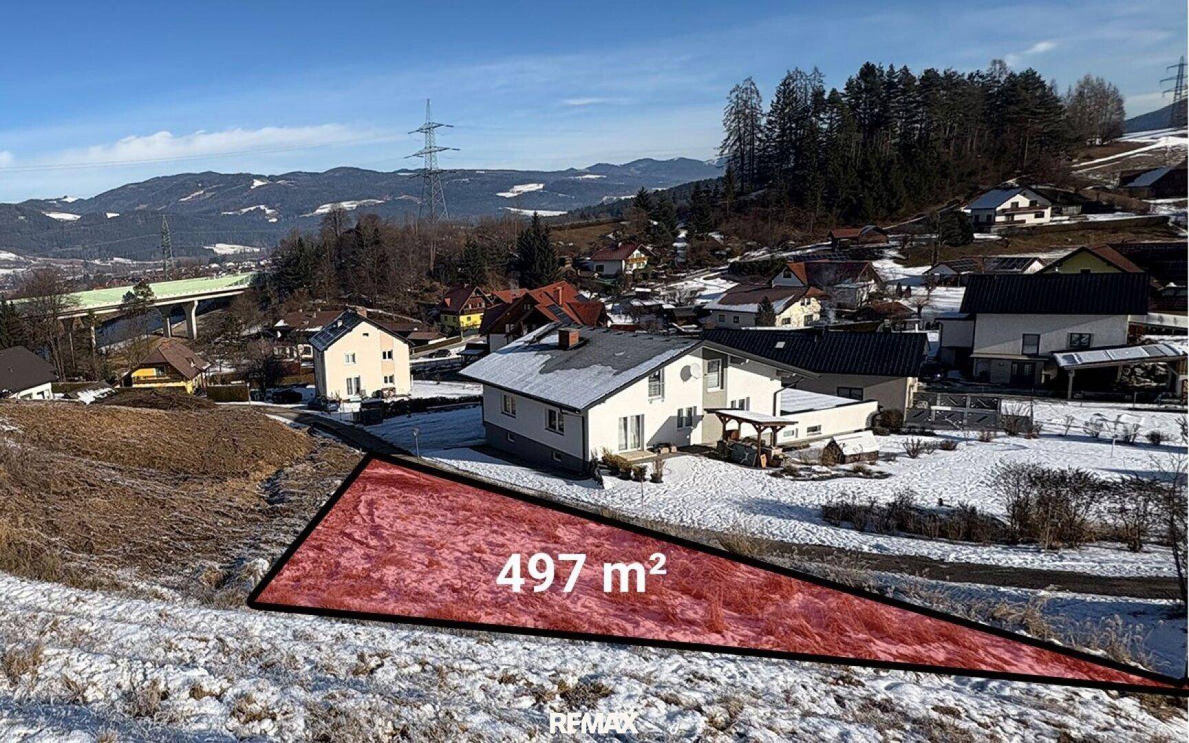 Winterliche Luftaufnahme eines Grundstücks von 497 m² in einer verschneiten Wohngegend.