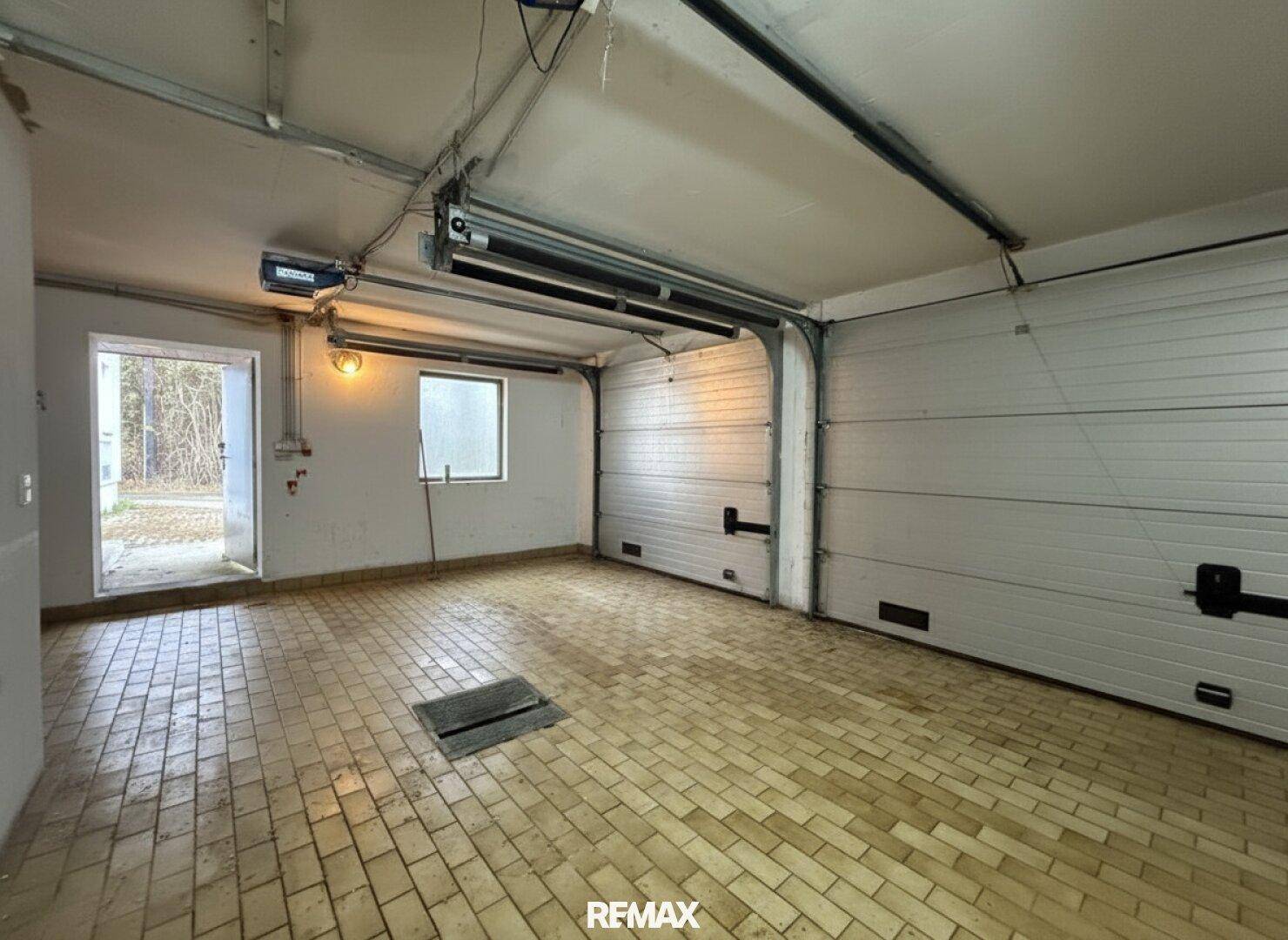 Geräumige Doppelgarage mit Fliesenboden und Rolltoren.