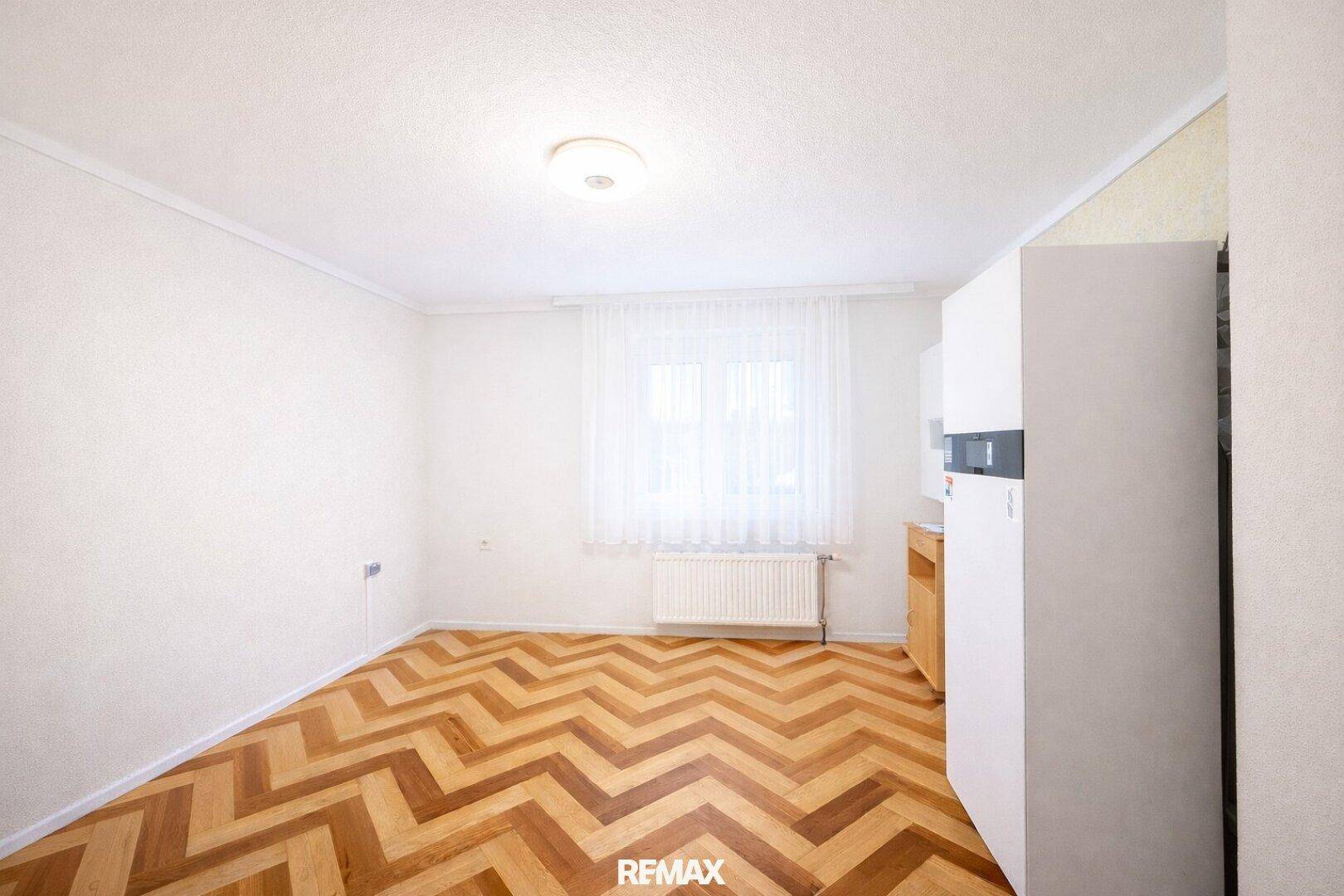 Helles Zimmer mit Fischgrätparkett und Fenster, ideal als Gäste- oder Kinderzimmer.