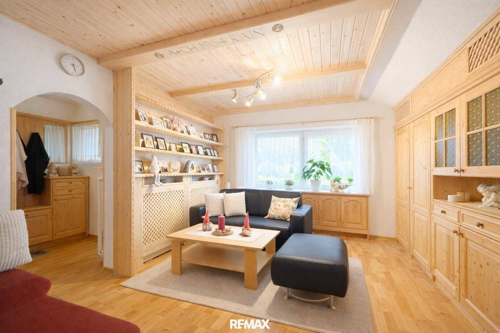 Rustikales Wohnzimmer mit Holzdecke, Einbauschränken und gemütlicher Sitzecke.