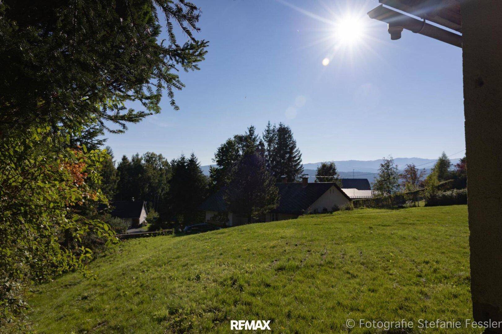 Sonnige Hanglage mit weitem Blick über die Landschaft und die umliegenden Berge.
