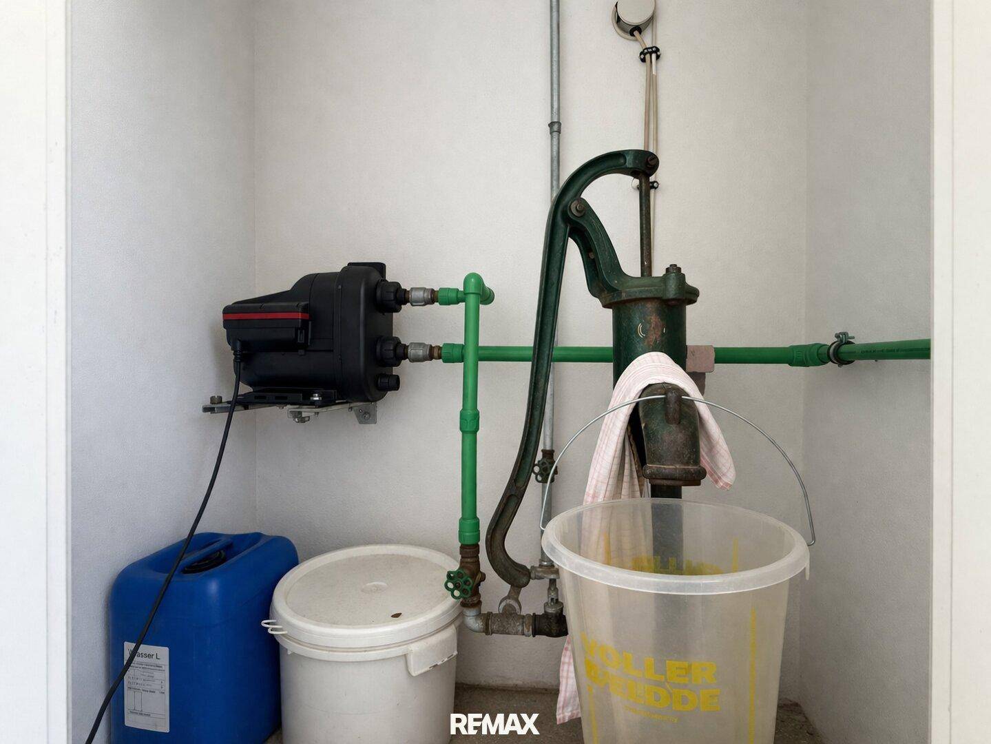 Technikraum mit Wasserpumpe und Leitungen, funktional eingerichtet.