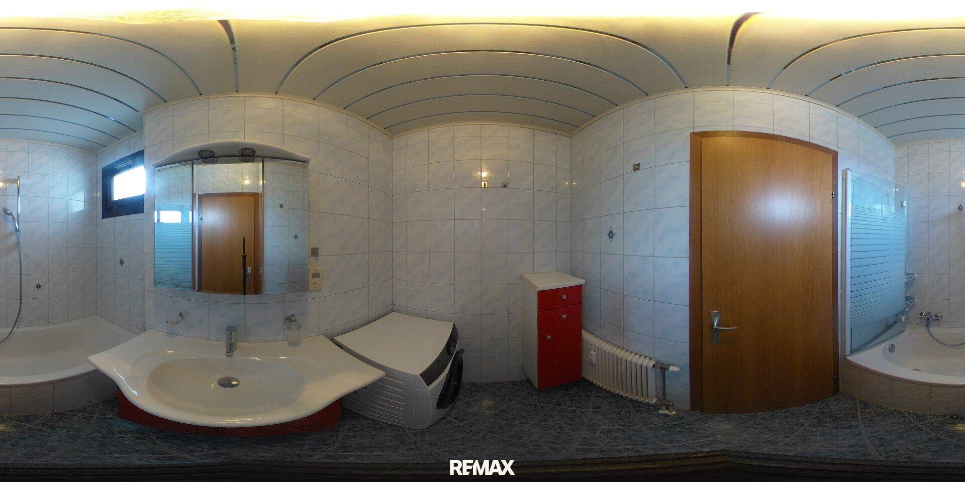 Gefliestes Badezimmer mit Badewanne, Waschbecken und Spiegelschrank, hell und funktional.